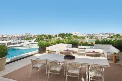 a balcony with a table and chairs and a pool at The Jeddah EDITION in Jeddah