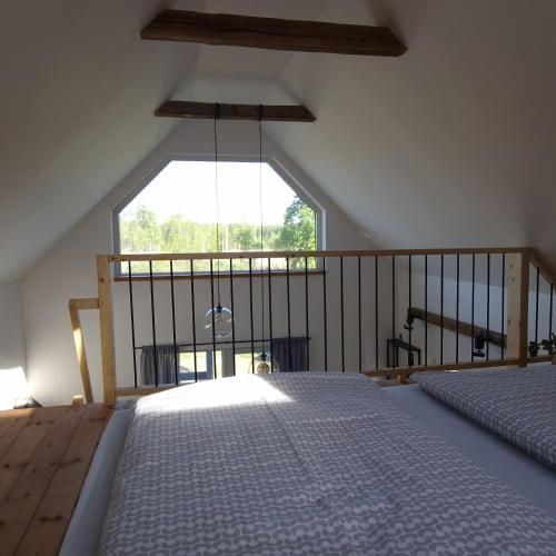 a bedroom with two beds and a large window at W ładnym polu n1 in Ruciane-Nida