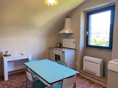 a kitchen with a blue table and chairs and a window at La Casa Medievale Suites e SPA in Pontremoli