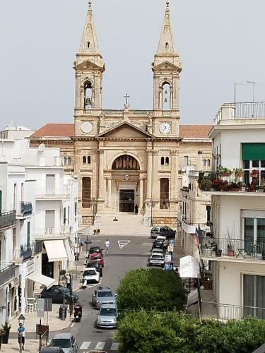 an old church with a clock tower in a city at La Casa del Corso in Alberobello