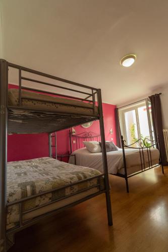two bunk beds in a room with pink walls at Hôtel La Barguelonne in Montcuq