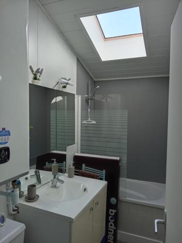 une salle de bain avec un lavabo, un miroir et une fenêtre dans l'établissement Pinede, à Carcans