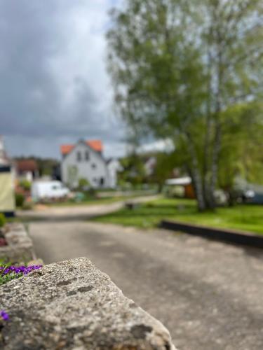a stone retaining wall with a house in the background at Fewo Haus Hutzelbuck in idyllisch-grüner Lage nähe AN in Ansbach