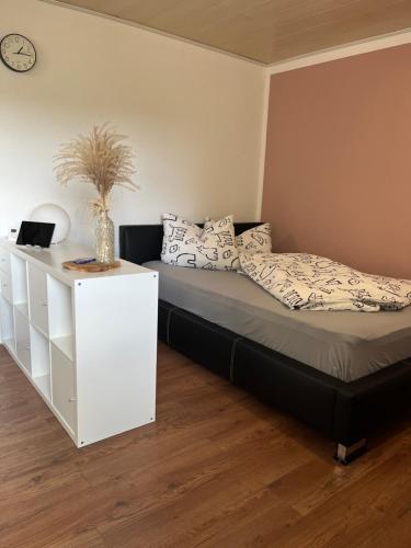 - une chambre avec un lit et une commode blanche dans l'établissement Fewo Haus Hutzelbuck in idyllisch-grüner Lage nähe AN, à Ansbach