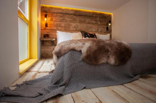 a bedroom with a bed with a large blanket on it at Higgihaus Aparthotel, Clare Street in Bristol