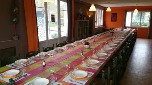 una mesa larga con platos y copas de vino. en Hôtel La Barguelonne en Montcuq