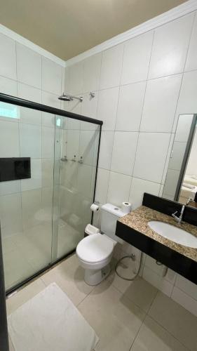 a bathroom with a toilet and a shower and a sink at Pousada Santa Fé in Aracaju