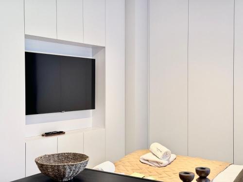 a living room with a tv and a table at Scala Apartamenty by Moderna Profit- Łąkowa 60C in Gdańsk