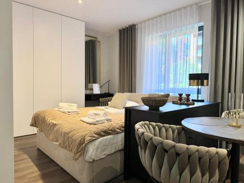 a bedroom with a bed and a table and chairs at Scala Apartamenty by Moderna Profit- Łąkowa 60C in Gdańsk