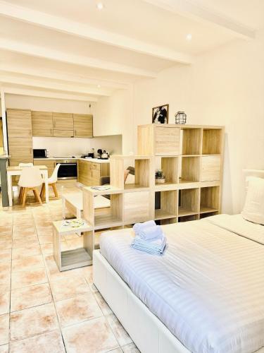 une chambre avec un grand lit et une cuisine dans l'établissement Grand Studio au Coeur de la Vieille Ville Clim, à Menton