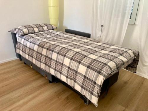 a bed in a room with a plaid blanket on it at Casa Nova Luxury Apartment Suite Limoni in Nova Milanese