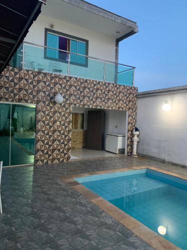 a house with a swimming pool in front of a house at Casa Branca in Londrina