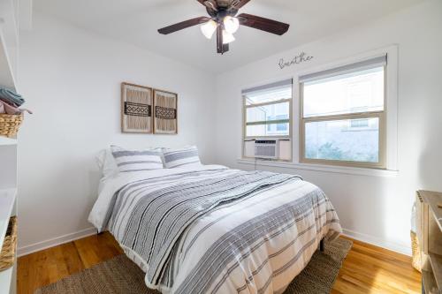 a white bedroom with a bed and a ceiling fan at Immaculate Charming Duplex - 2unit in Oroville