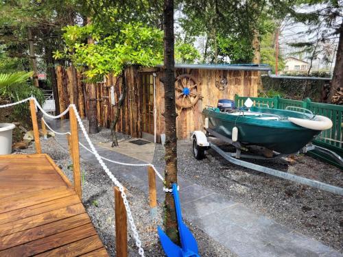 a green boat parked next to a wooden fence at Bateau sur terre près du bassin in Capvern