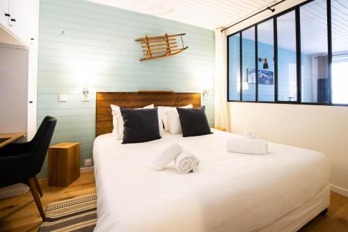 une chambre avec un grand lit blanc avec une fenêtre dans l'établissement Dauphin vieille ville Annecy ancien couvent 1638, à Annecy