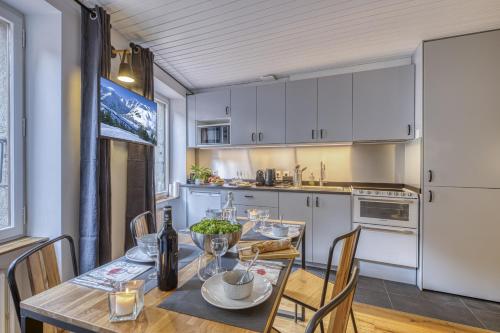 une cuisine et une salle à manger avec une table et des chaises dans l'établissement Dauphin vieille ville Annecy ancien couvent 1638, à Annecy
