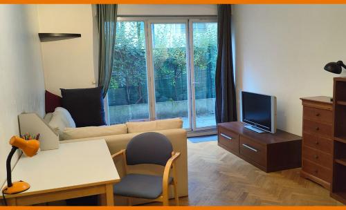 un salon avec un canapé et une télévision dans l'établissement Your lovely parisian 2 rooms apartment with private terrace - Jourdain, à Paris