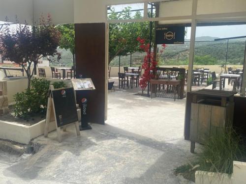 a restaurant with tables and chairs in a building at Popi's Apartment in Goníai