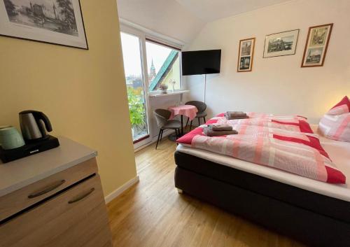 1 dormitorio con cama, escritorio y ventana en Hotel Nordlicht, en Schwerin