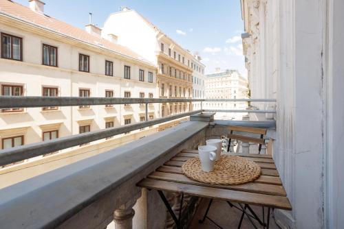 una mesa en un balcón con vistas a un edificio en 4ty3 Apartments - Stadtpark City Apartment is calling, en Viena