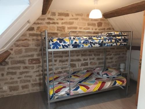 2 łóżka piętrowe w pokoju z ceglaną ścianą w obiekcie Au calme w mieście Lalheue