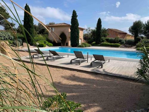 un groupe de chaises assises à côté d'une piscine dans l'établissement Villa VESTA 62m2 à St Cyprien 700 m de la plage et du village, à Lecci