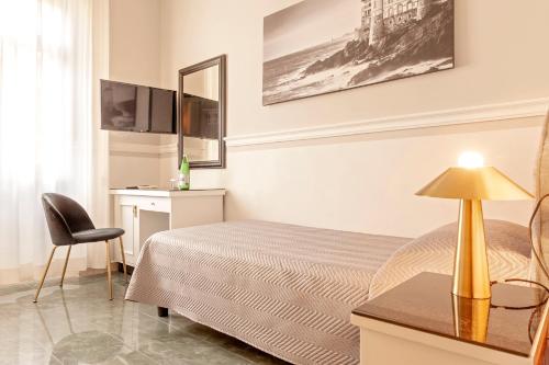 Schlafzimmer mit einem Bett, einem Schreibtisch und einem Stuhl in der Unterkunft The Port Residence in Livorno
