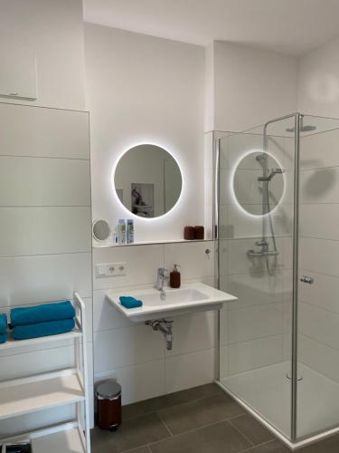 biała łazienka z umywalką i prysznicem w obiekcie Ebelsberger Terrassen w Linzu