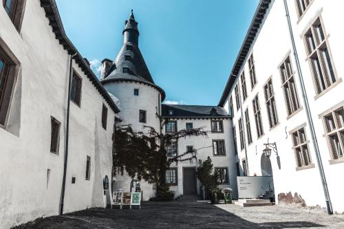 a large white building with a black turret at Koener Hotel & Spa in Clervaux