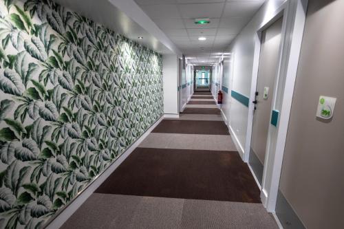 a hallway in an office with a mural on the wall at Campanile Belfort Montbéliard - Gare La Jonxion. in Meroux