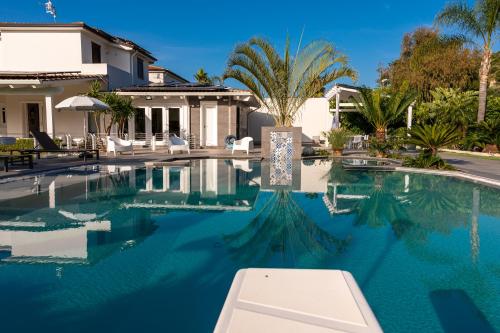 a swimming pool in front of a house at Villa Solià - Villa indipendente con Piscina e Giardino in Campofelice di Roccella