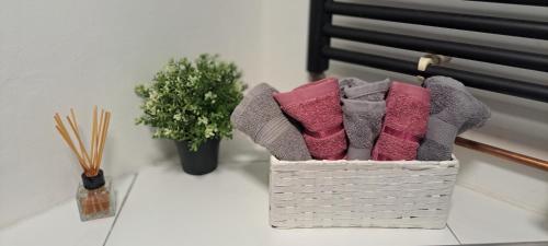 uma cesta de toalhas em uma mesa ao lado de uma planta em Apartman Moonlite em Čakovec