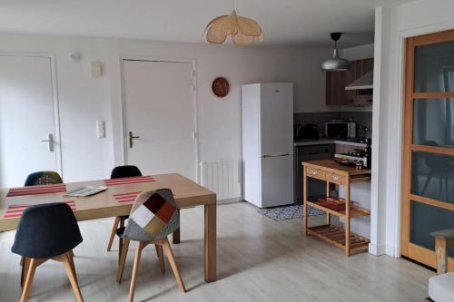 une cuisine avec une table, des chaises et un réfrigérateur dans l'établissement Charmant T3, 200m du Port, Plage à Pied - Appart 4, à Binic