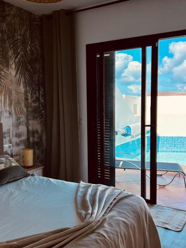 a bedroom with a bed and a view of a pool at Trendy Villa Isabella, heated pool in Playa Blanca