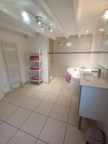 biała łazienka z umywalką i toaletą w obiekcie Au calme w mieście Lalheue