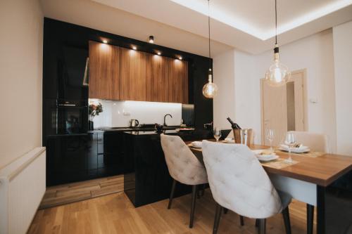 kuchnia z drewnianym stołem i białymi krzesłami w obiekcie Prestige w mieście Trebinje