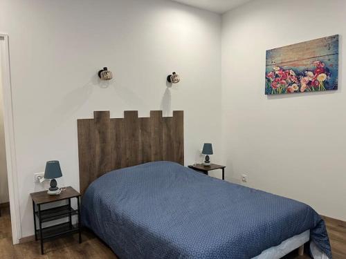 a bedroom with a blue bed and a painting on the wall at Le bleuet in Montréjeau