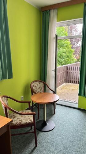 a room with a table and two chairs and a window at Grandhotel Nový Bor in Nový Bor