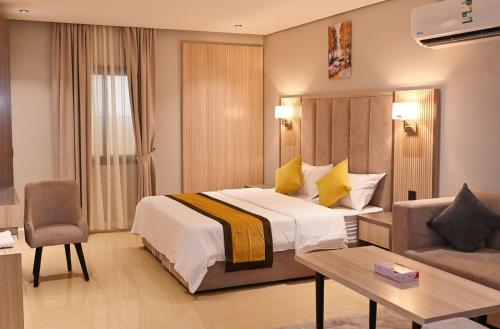 une chambre d'hôtel avec un lit et un canapé dans l'établissement بلند للشقق المخدومة, à Dammam