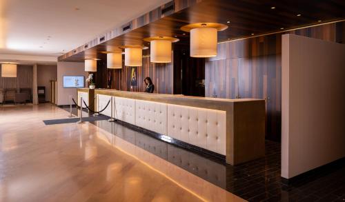 a lobby with a bar with lights on the wall at Mövenpick Hotel & Casino Geneva in Geneva