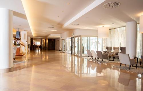 un hall avec des chaises et une table dans un bâtiment dans l'établissement Mövenpick Hotel & Casino Geneva, à Genève