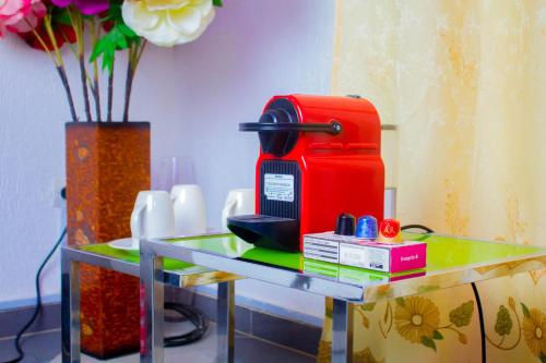 une table en verre avec une machine rouge en haut dans l'établissement Appartement de Haut Standing à Abomey-Calavi, à Abomey-Calavi