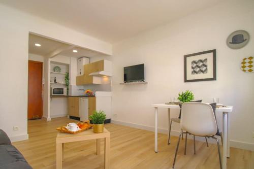 Una sala de estar con una mesa y una cocina. en Le Gallieni By ApiRent #Centre-ville #Lumineux #Wifi, en Cannes