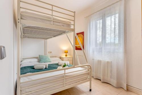 a bedroom with a bunk bed and a window at Chalet Irene, mit Pool und Wifi in Santanyi