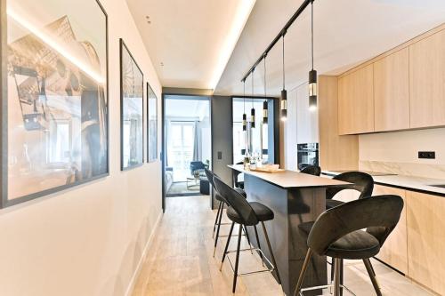 - une cuisine avec des chaises noires et une table dans une chambre dans l'établissement Appartement luxueux Musée du Louvre - Rivoli, à Paris