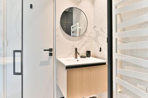 une salle de bain avec un lavabo et un miroir dans l'établissement Appartement luxueux Musée du Louvre - Rivoli, à Paris