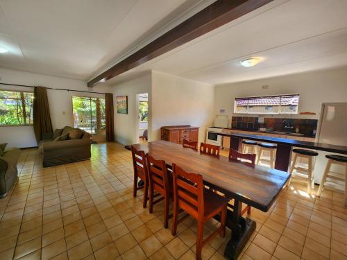 cocina y sala de estar con mesa de madera y sillas en Pine Valley en Lanseria