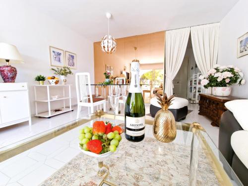 eine Flasche Wein und Obst auf einem Tisch im Wohnzimmer in der Unterkunft Happy in Holiday Miraflores Apartments in Mijas