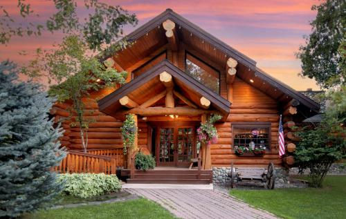 a log cabin with a front door and a porch at Lochsa Lodge in Lolo
