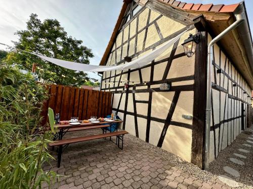 uma mesa com comida ao lado de um edifício em Alsace Gîte 3 étoiles "Coeur de Cigogne" - 15mn Strasbourg Obernai - Clim Wifi Parking gratuit em Hangenbieten